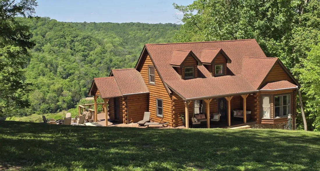 Large restored log home in an open field